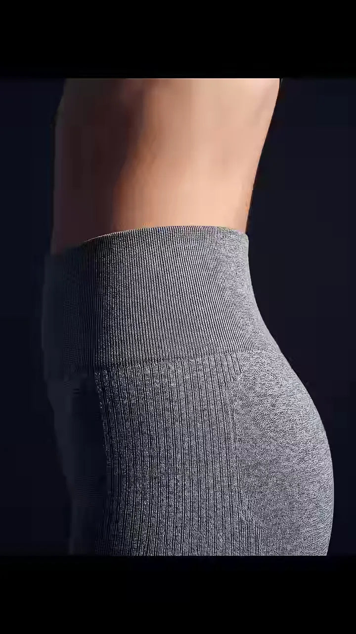 Le Legging Sculptant, gris ardoise — la ceinture et la hanche, de profil et de près, sous une lumière rasante.